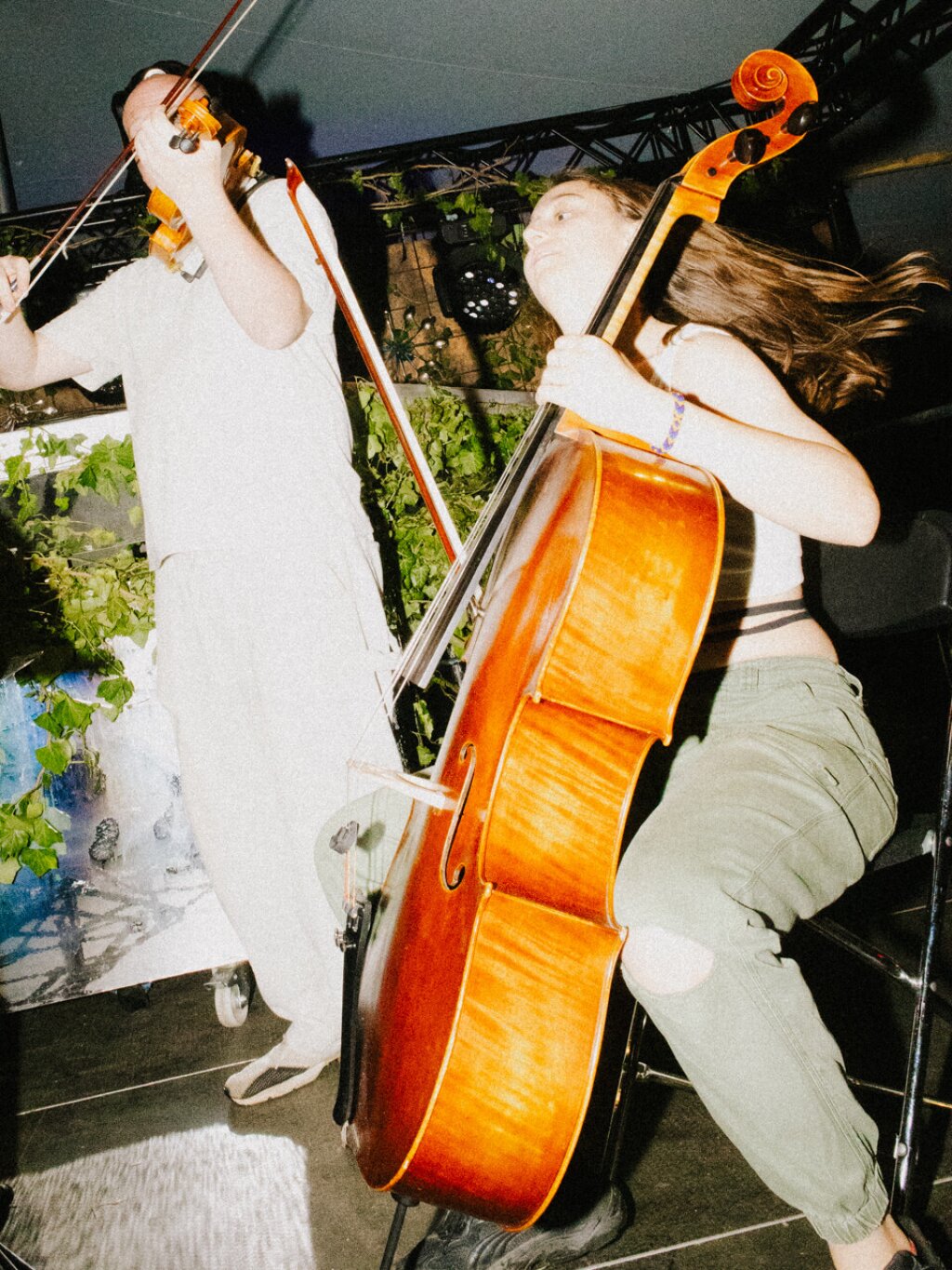 A violinist and a cellist on a stage.